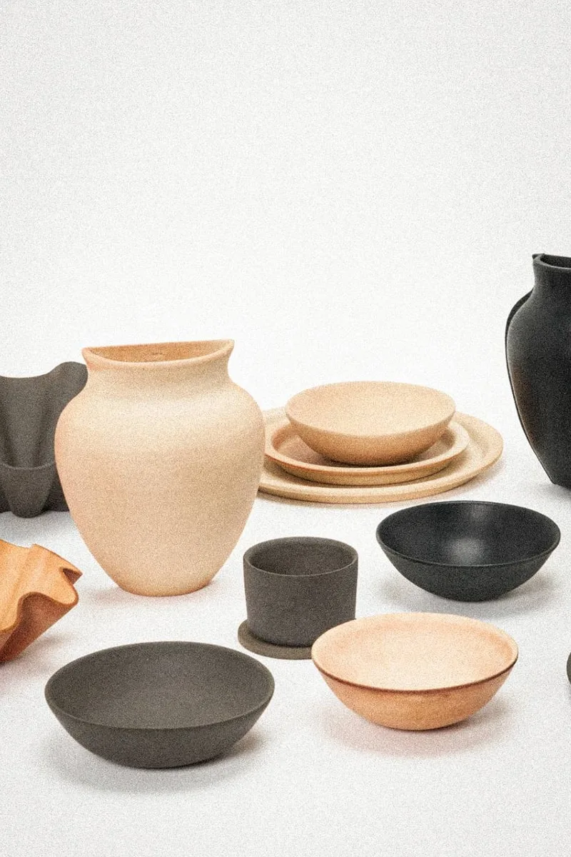Collection de poteries en tons naturels sur fond blanc, assiettes et bols.