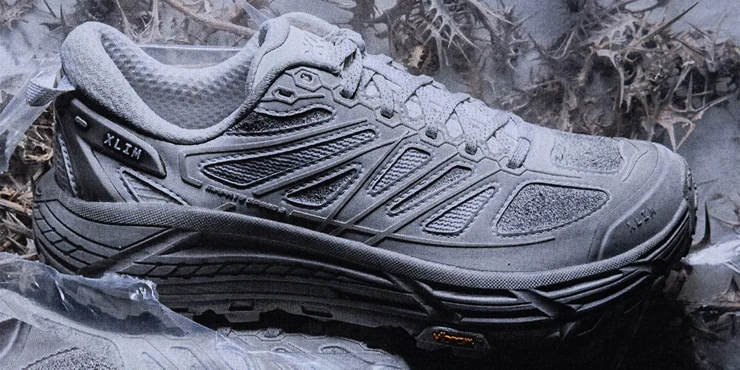 Chaussure de sport grise avec détails complexes, sol rugueux.