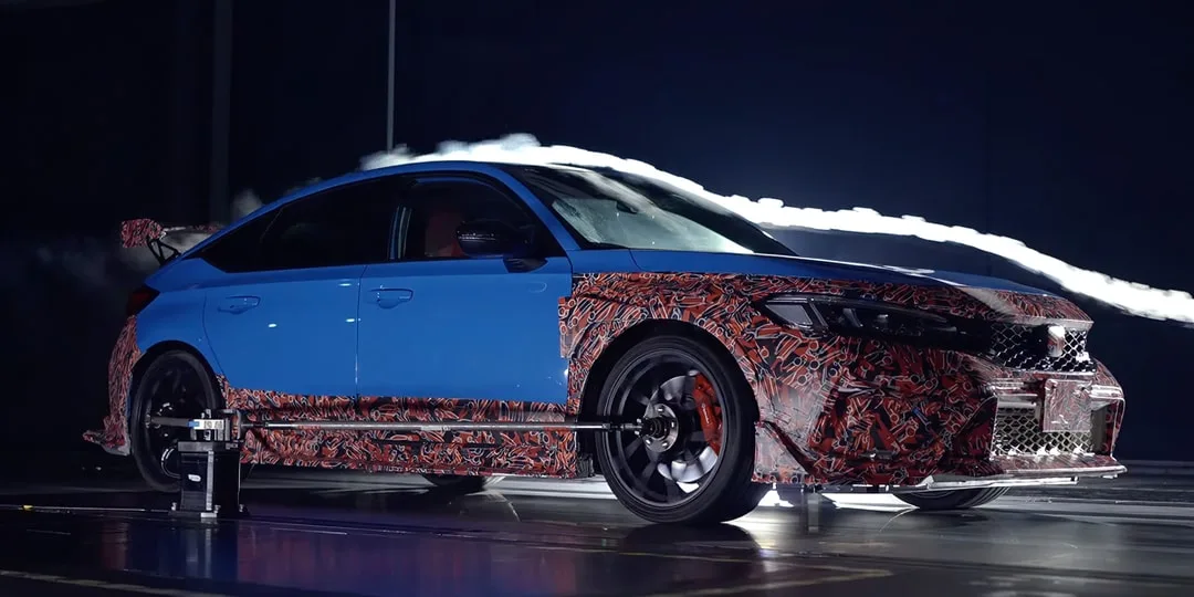 Voiture bleue avec design camouflage en test aérodynamique.