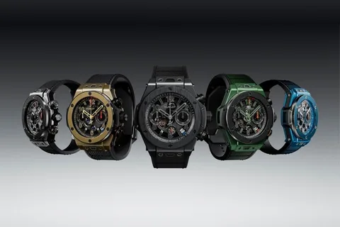 Cinq montres avec bracelets colorés sur fond gris.