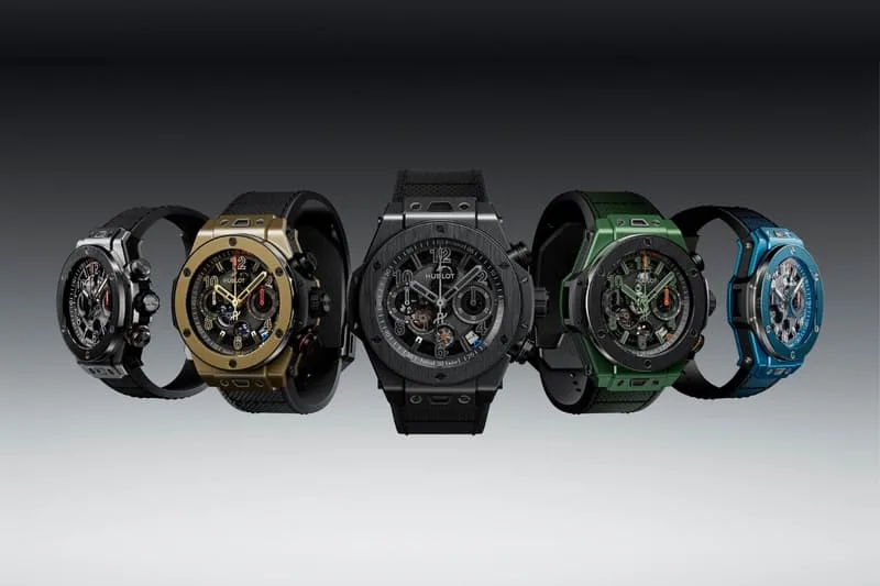 Cinq montres avec bracelets colorés sur fond gris.