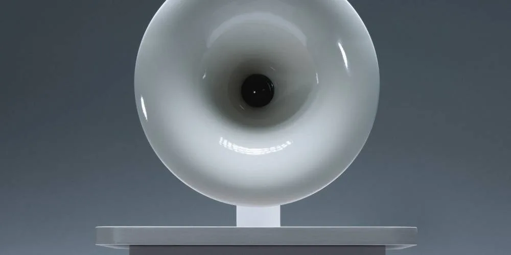 Sculpture circulaire blanche sur socle, arrière-plan gris