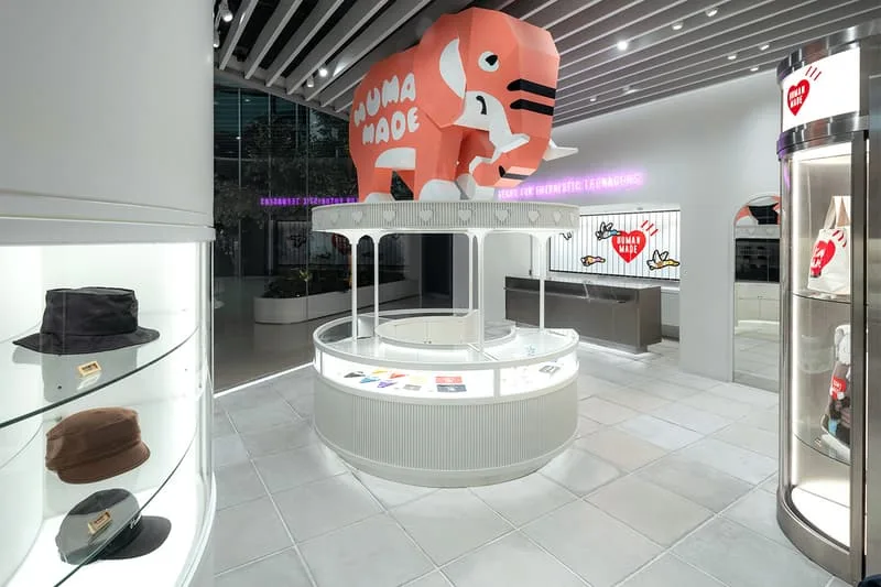 Magasin avec grand éléphant rose, chapeaux exposés, design moderne et lumineux.