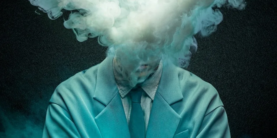 Personne en costume avec fumée blanche couvrant la tête