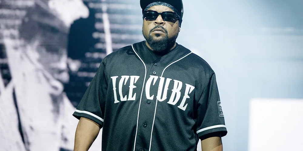 Personne portant des lunettes de soleil et un maillot 'Ice Cube'.