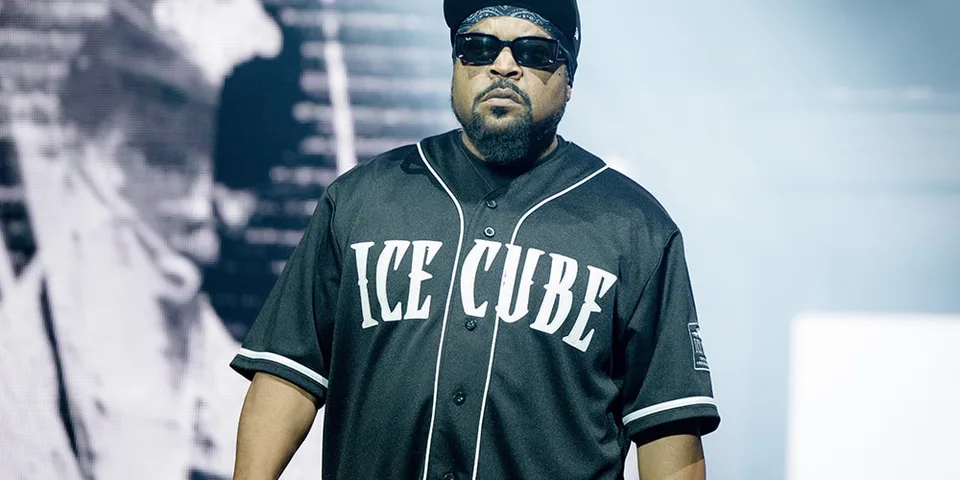 Personne portant des lunettes de soleil et un maillot 'Ice Cube'.