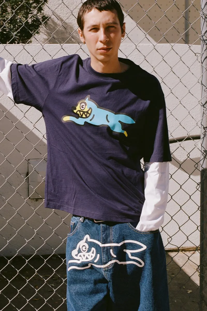 Homme en jeans et t-shirt avec dessins stylisés.