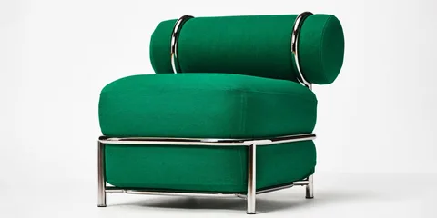 Fauteuil vert avec structure métallique moderne, design épuré et élégant.