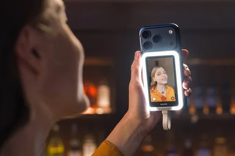 Femme utilisant un smartphone avec un anneau lumineux, montre son image à l'écran.