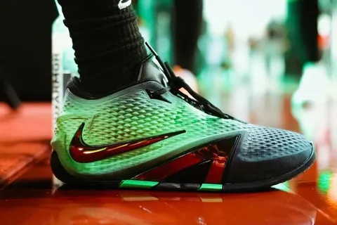 Gros plan d'une chaussure de sport verte avec logo Nike rouge.