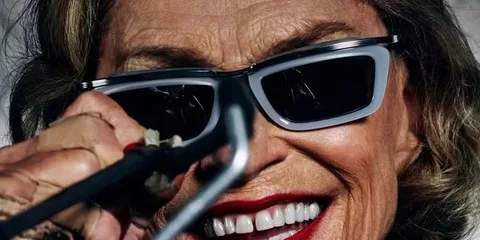 Visage souriant avec lunettes de soleil et maquillage voyant.