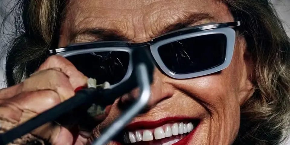 Visage souriant avec lunettes de soleil et maquillage voyant.