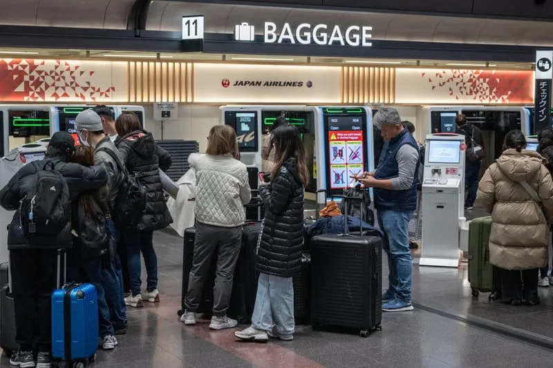 Passagers au centre de bagages de Japan Airlines dans un aéroport.