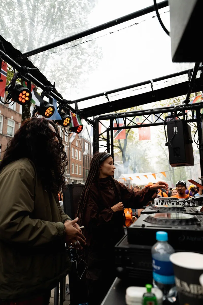 DJ et musique en plein air avec des drapeaux et une foule.