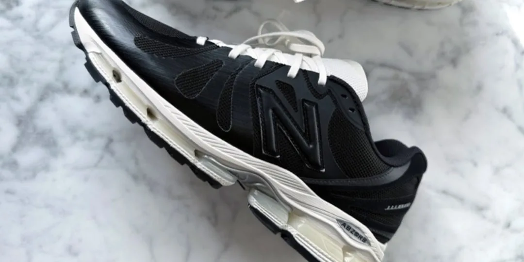 Chaussure de sport noire et blanche sur fond marbré.