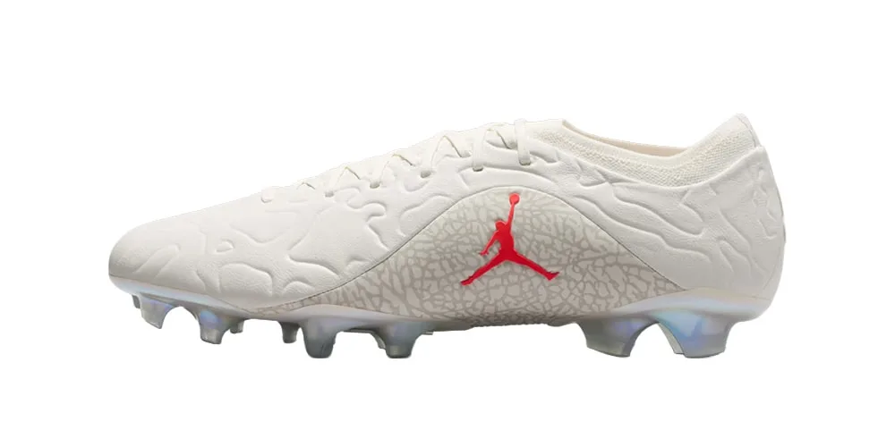 Chaussure de football blanche avec logo rouge Jumpman et crampons translucides.