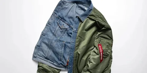 Veste hybride en jean et bomber vert, posée à plat.