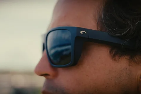 Gros plan sur un homme portant des lunettes de soleil noires.