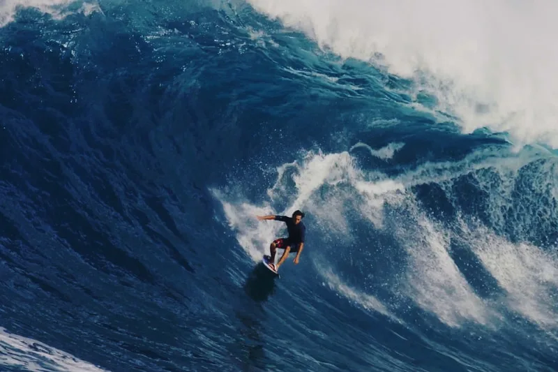 Surfeur chevauchant une grande vague océanique