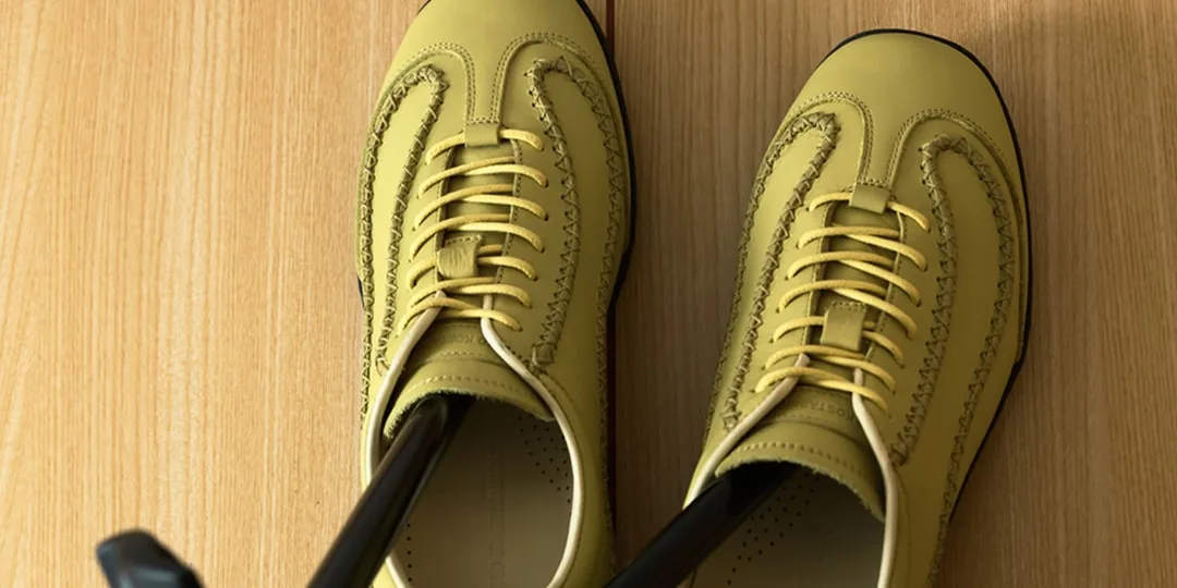 Chaussures jaunes avec lacets sur un sol en bois.