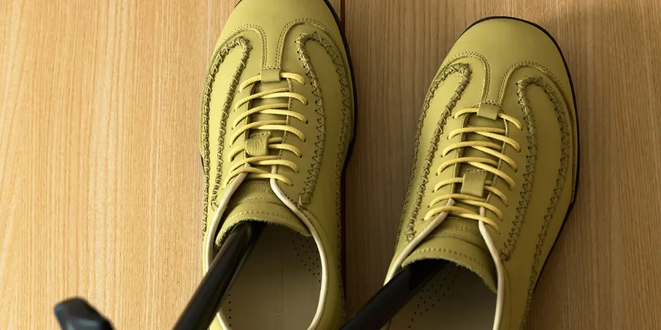 Chaussures jaunes avec lacets sur un sol en bois.