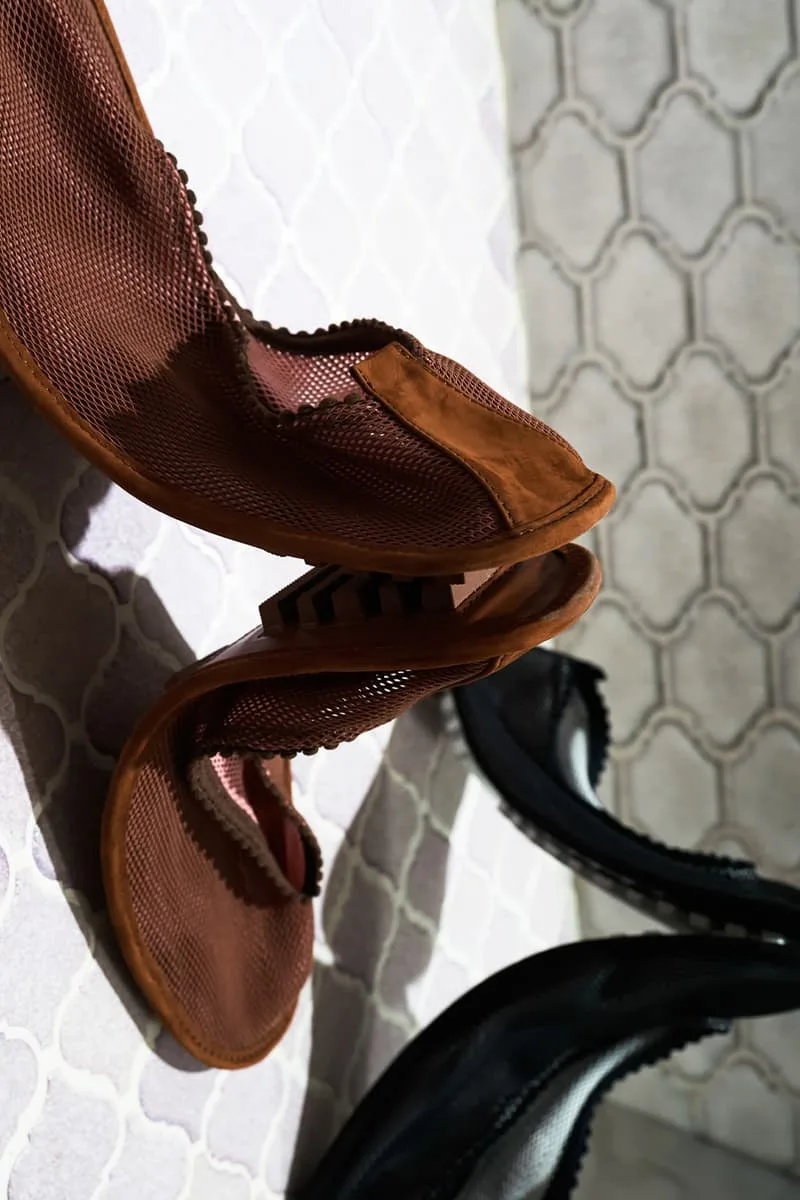Chaussures avec effet maille, sur un sol carrelé clair et ombragé.