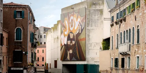 Peinture murale colorée dans une rue étroite avec bâtiments anciens à Venise.