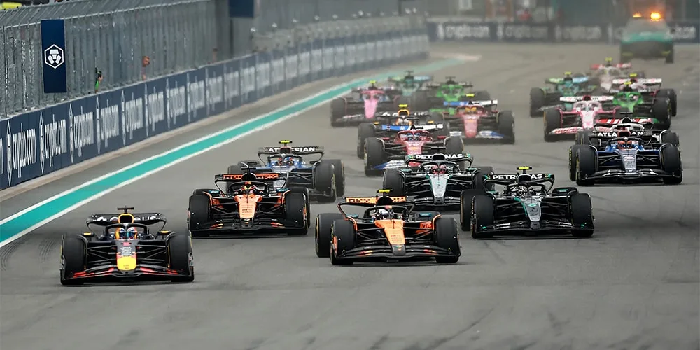 Voitures de course sur une piste, plusieurs voitures en compétition.