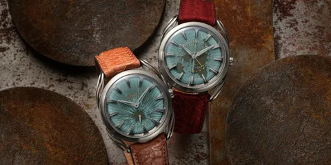 Deux montres avec bracelets en cuir et cadrans bleus texturés.