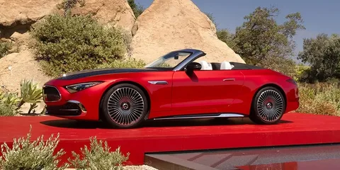 Voiture décapotable rouge sur fond de paysage rocheux.