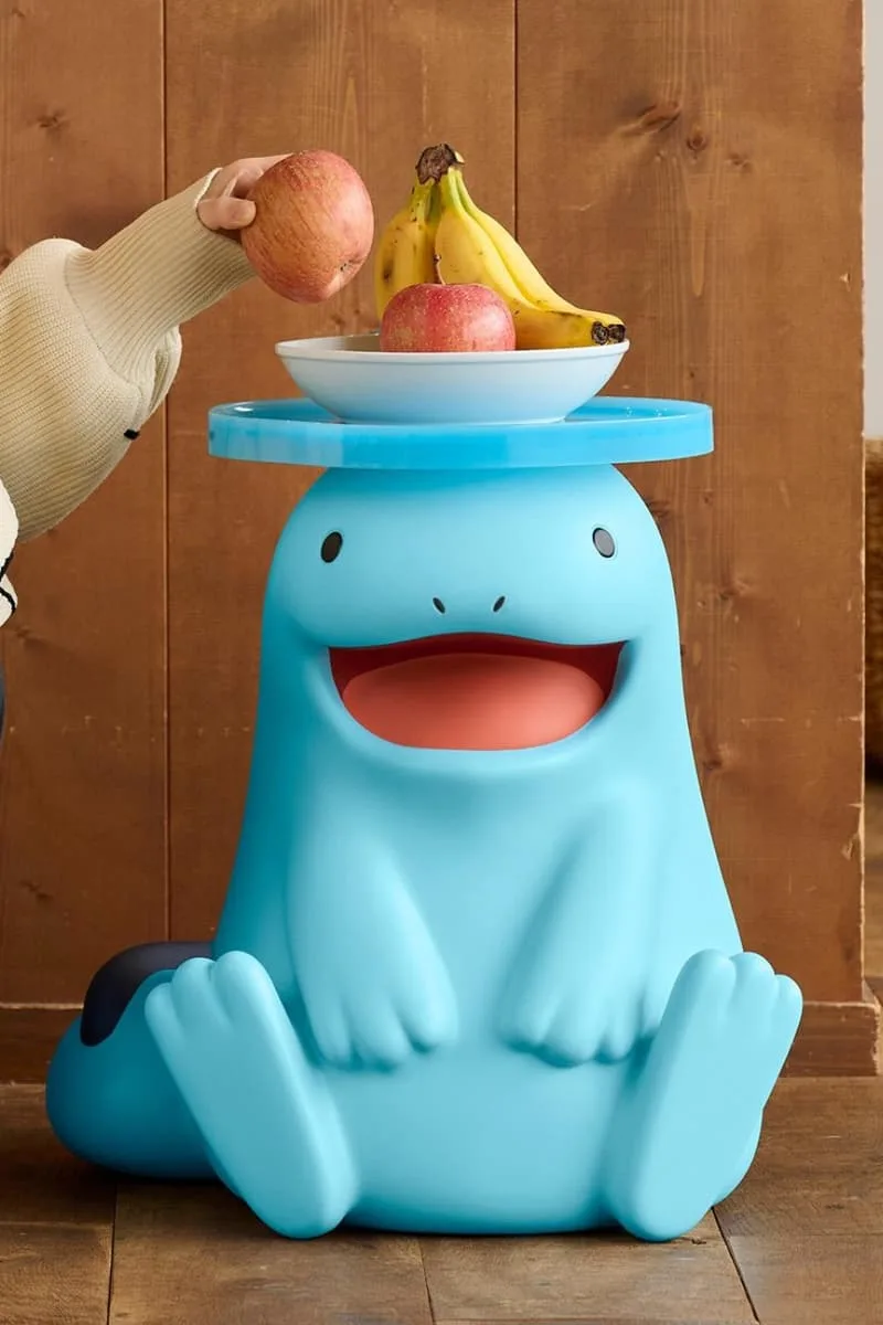 Tabouret bleu en forme de personnage avec fruits sur le dessus
