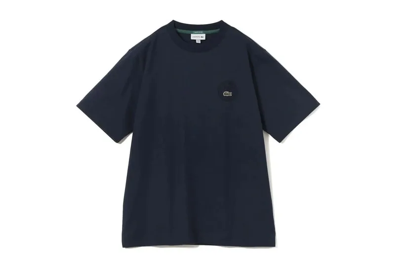 T-shirt bleu foncé avec logo rond sur le devant, fond blanc.