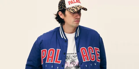 Homme avec casquette et veste bleu, logo Palais visible.