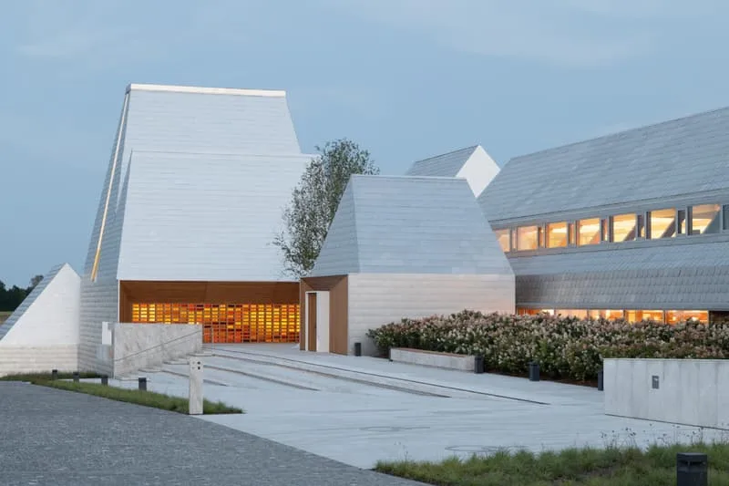 Bâtiment moderne avec toit en pente et éclairage intérieur visible