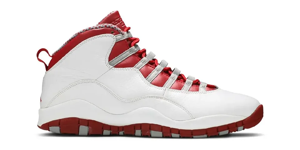 Chaussure de sport blanche et rouge avec semelle crantée.