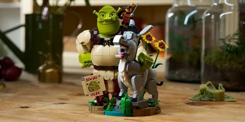 Figurines de Shrek, âne et chat en bottes en briques, décor de fleurs.