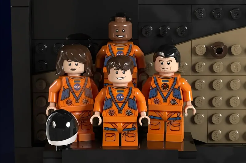 Figurines LEGO en tenue spatiale orange avec logo NASA sur fond de briques.