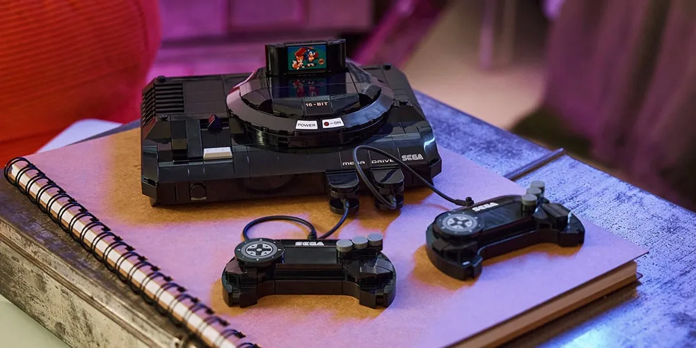 Console de jeu rétro SEGA avec manettes, sur un carnet.