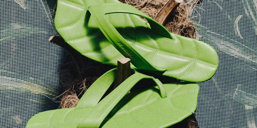 Tongs vertes en forme de feuilles sur un fond naturel.