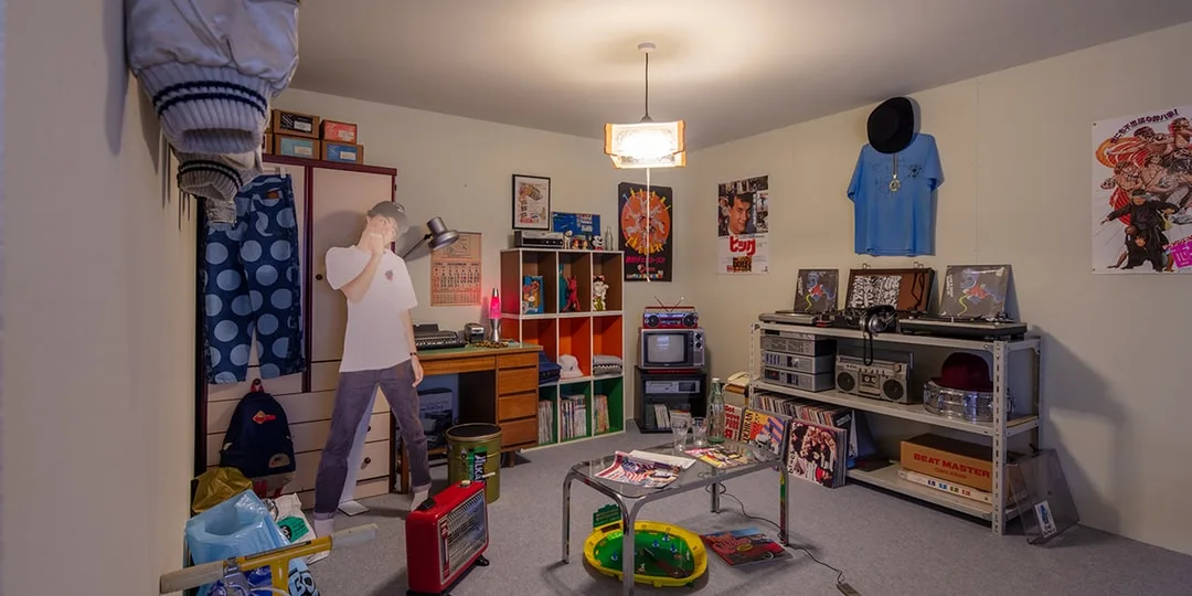 Chambre rétro avec déco années 80, mannequin, affiches et électronique vintage.