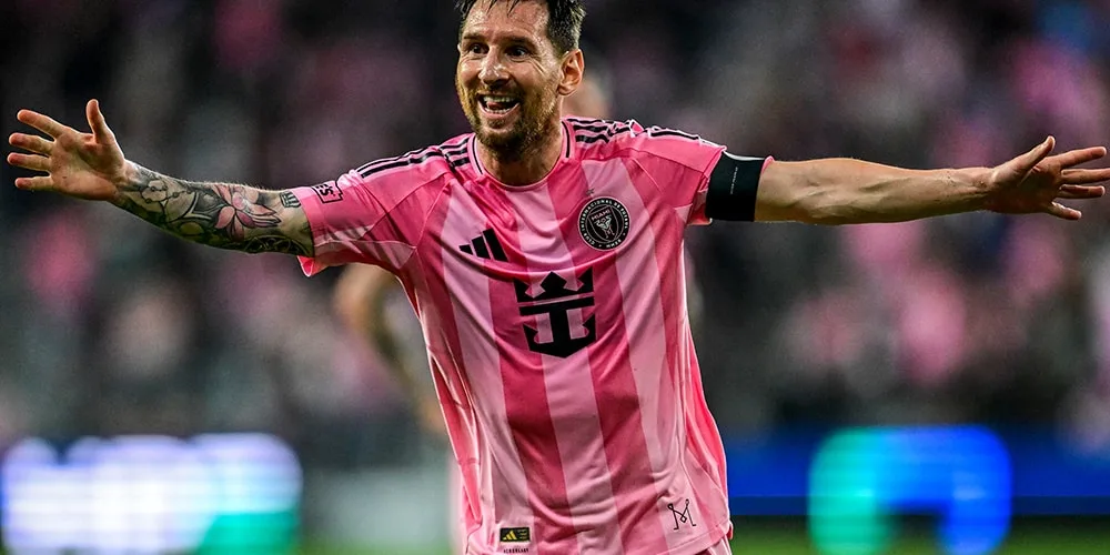 Joueur de football en maillot rose célébrant un but.