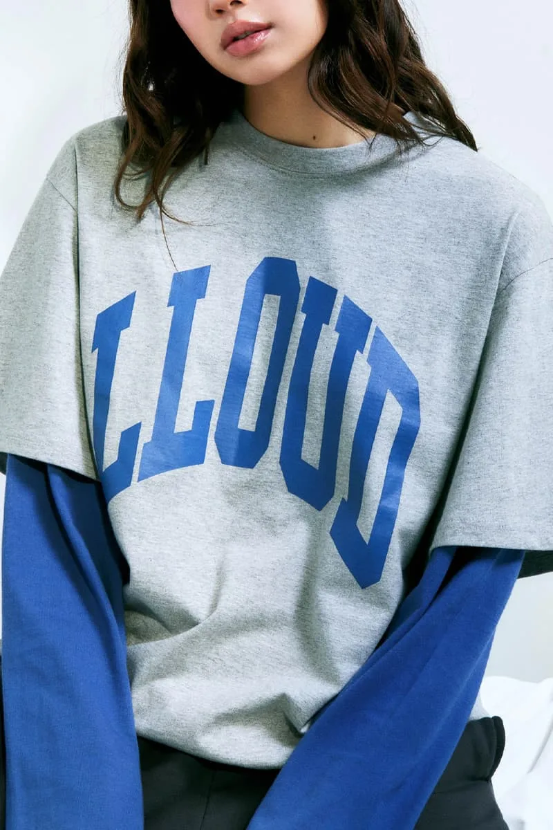 Femme portant un t-shirt gris avec texte bleu LLUUD