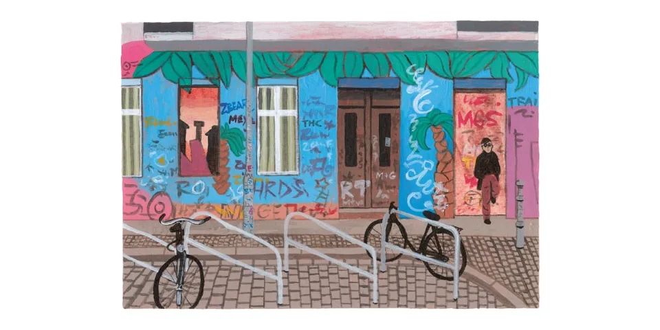 Bâtiment coloré avec graffitis, vélos attachés devant.