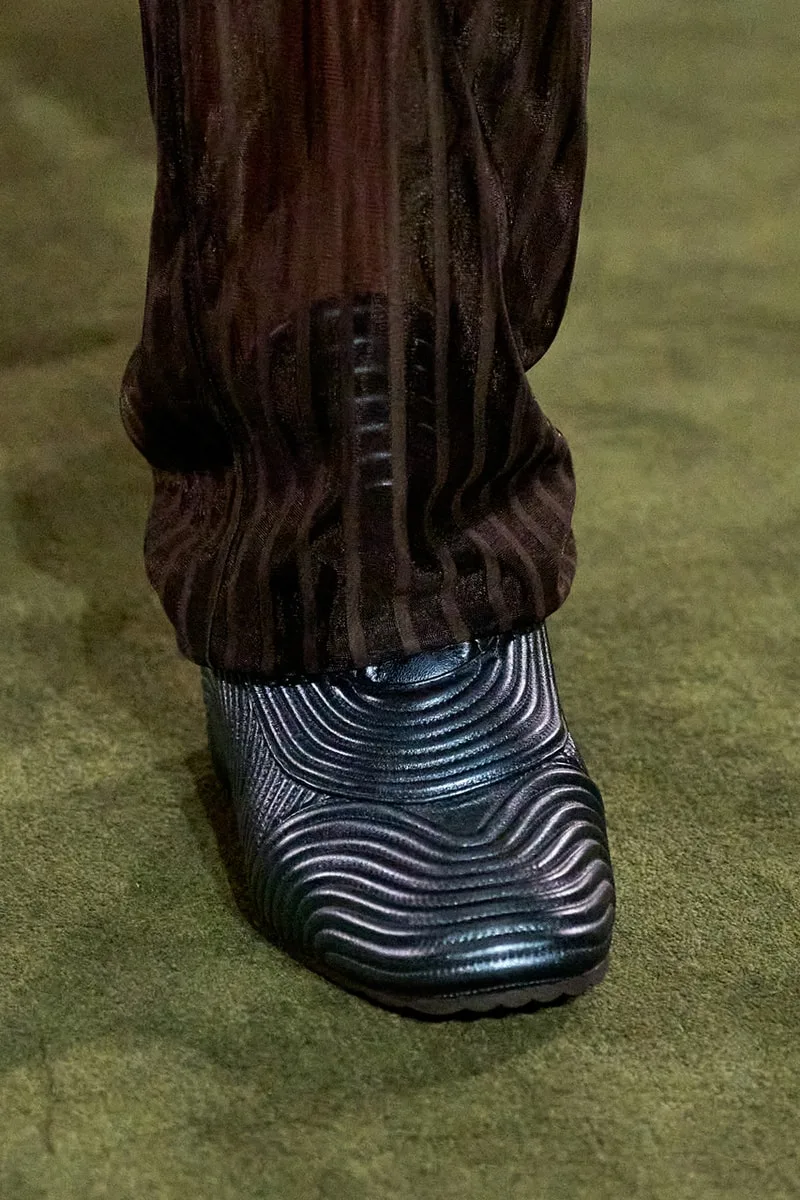 Chaussure texturée noire sur fond vert.