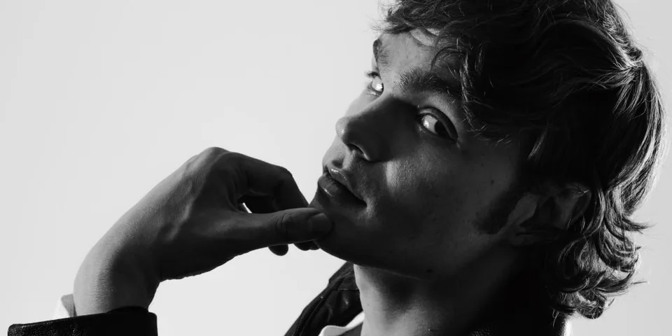 Portrait en noir et blanc d'un homme pensif avec regard tourné.