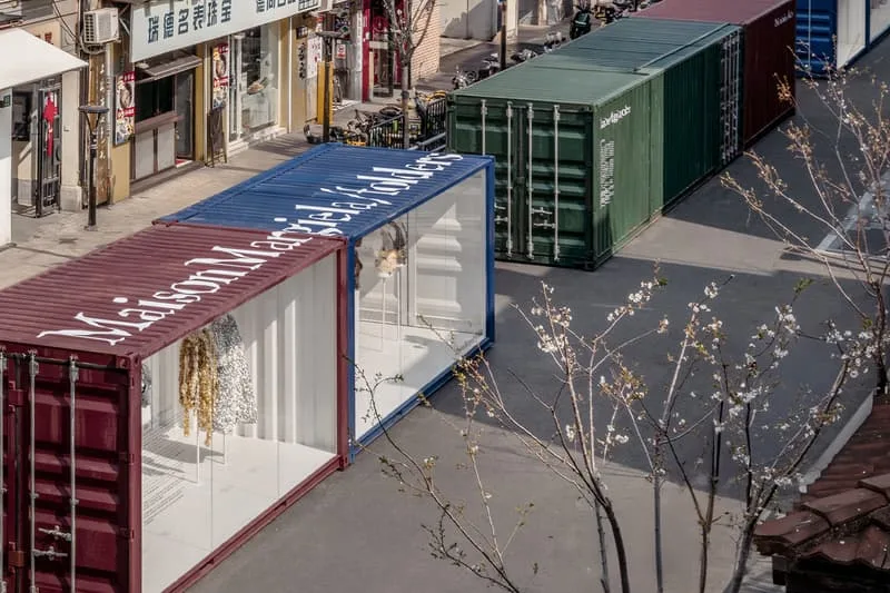 Containers colorés dans une rue, magasins en arrière-plan.