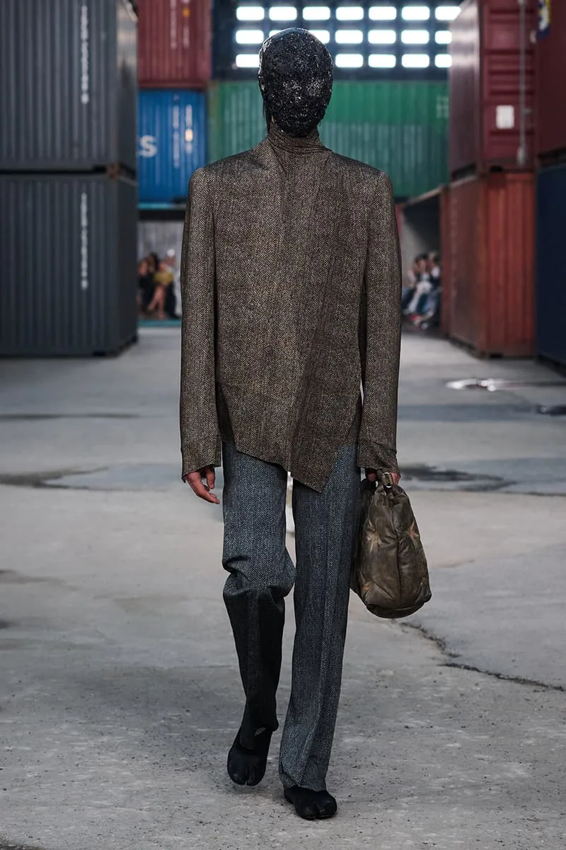 Collection Maison Margiela FW26 à la Shanghai Fashion Week par Glenn Martens : Maison Margiela FW26 apporte un marché aux puces parisien dans un chantier naval de Shanghai, prêt-à-porter artisanal