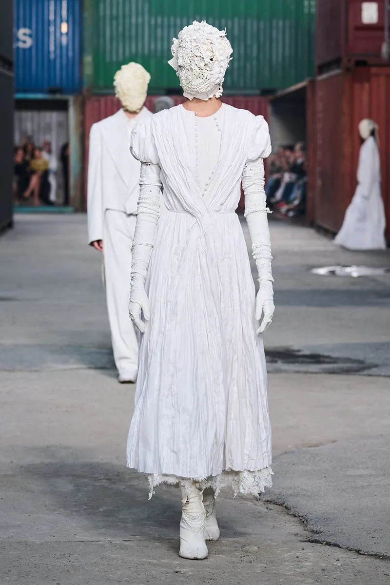 Collection Maison Margiela FW26 à la Shanghai Fashion Week par Glenn Martens : Maison Margiela FW26 apporte un marché aux puces parisien dans un chantier naval de Shanghai, prêt-à-porter artisanal