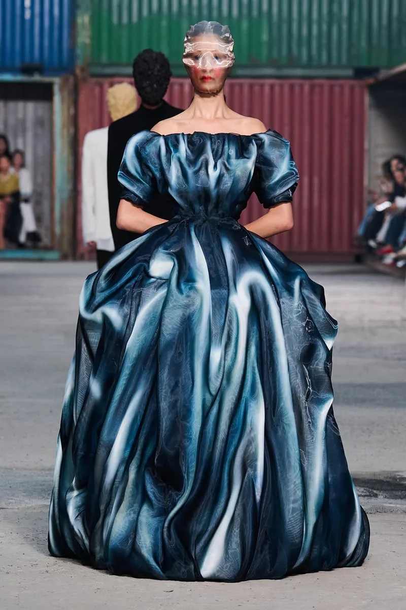Collection Maison Margiela FW26 à la Shanghai Fashion Week par Glenn Martens : Maison Margiela FW26 apporte un marché aux puces parisien dans un chantier naval de Shanghai, prêt-à-porter artisanal