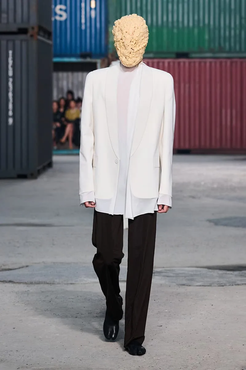 Collection Maison Margiela FW26 à la Shanghai Fashion Week par Glenn Martens : Maison Margiela FW26 apporte un marché aux puces parisien dans un chantier naval de Shanghai, prêt-à-porter artisanal